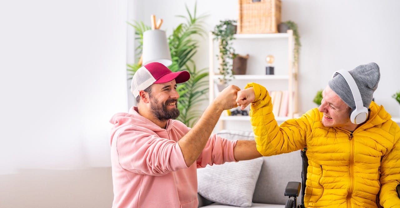 Disabled man and friend giving each other a fist bump